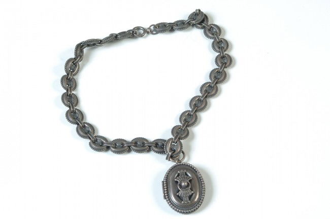 A VICTORIAN SILVER BOOK CHAIN WITH LOCKET: Locket measures 1.5 x 1.25 inches, hinged, with two photos of a man inside; sprung catch