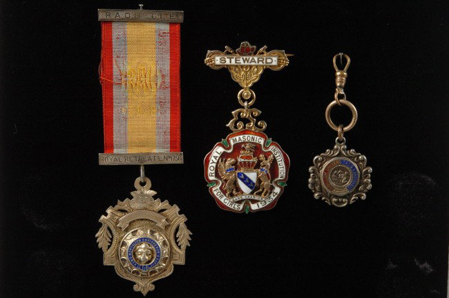 THREE STERLING WITH ENAMEL MEDALS AND FOB: Includes two English medals, Royal Masonic Institution for Girls 1934 'Steward' medal, marked 'Kensington, London' to reverse, measures approximately 3 inches from brooch to bottom of medal; and a tem
