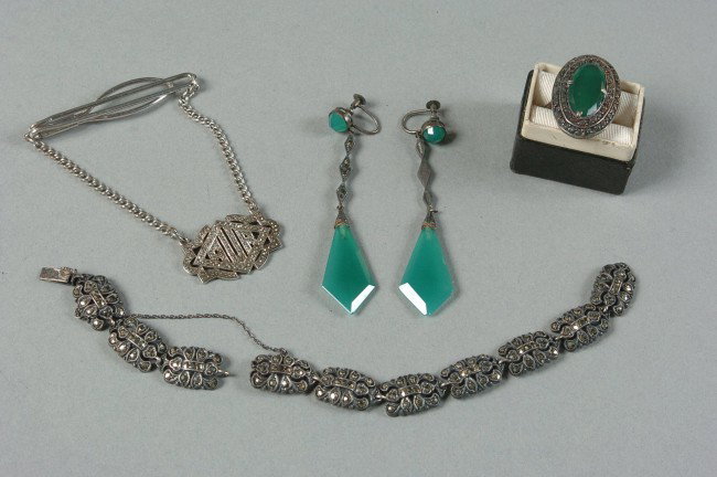 LOT OF ART DECO STERLING AND MARCASITE JEWELRY: Includes a pair of sterling marked earrings with cut green stones, matching ring size 9. A ten segment silver bracelet all with marcasites; and a sterling marked tie bar with suspended marcasite encru