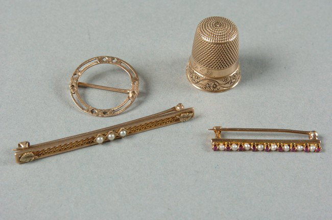 GROUP OF GOLD JEWELRY: Includes a 10K marked round pin, split at one end, 3/4 inch; a 1.25 inch bar pin with seed pearls and red stones, an unmarked 2 inch bar pin with pearls, and a small thimble.