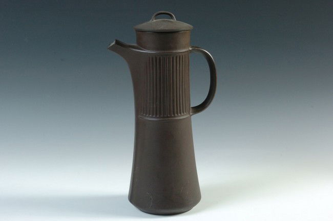 A JENS QUISTGAARD COVERED TANKARD FOR DANSK: A industrial brown matte tankard with partially fluted pattern side, cream interior. Stands 13.5 inches. Bottom signed 'Dansk Designs of Denmark, IHQ.'