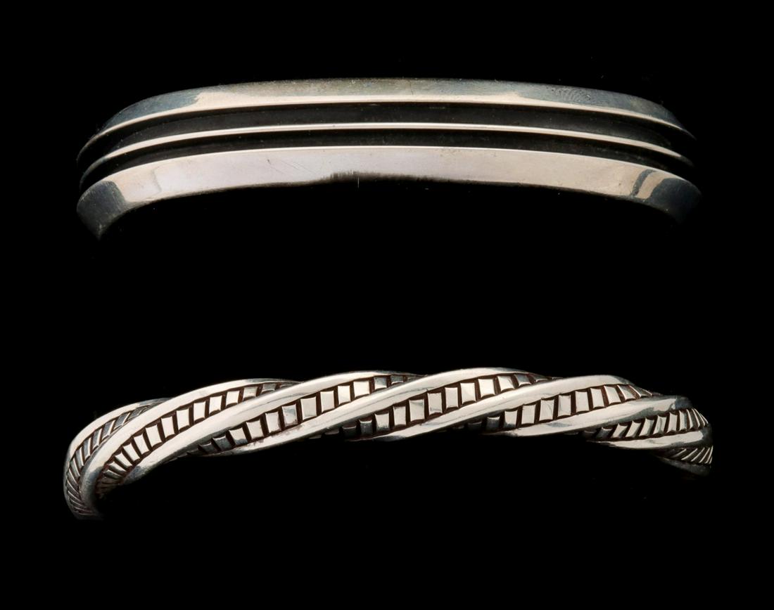 TWO SIGNED NAVAJO STERLING SILVER CUFF BRACELETS: 1) Tom Hawk sterling cuff bracelet with deep oxidized furrows. 2) Albert Lee sterling cuff bracelet of twisted zippers design. Bracelet wrist circumferences are 6.25 and 6.5 inches. Each has an openin