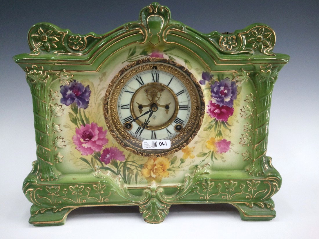 ANSONIA ROYAL BONN 'LA PALMA' CHINA CASE CLOCK: Circa 1905 with shaded green china case decorated wit floral transfers trimmed in gold, double sunk enamel dial with exposed escapement, signed Royal Bonn case, measures 11.75 x 14 x 5 inches overall.