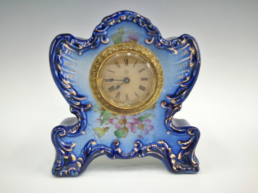 AN ANSONIA 'CHICKADE' FLOW BLUE CHINA CLOCK: Signed Ansonia on the original paper dial, marked 'Chickadee' on the china case, measures 6 x 6 inches, no chips, cracks or repairs.