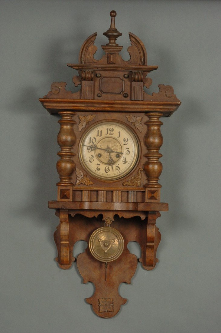 A GERMAN OPEN WAG WALL CLOCK: Movement marked FNS. 37 x 17 x 7.25 inches overall.