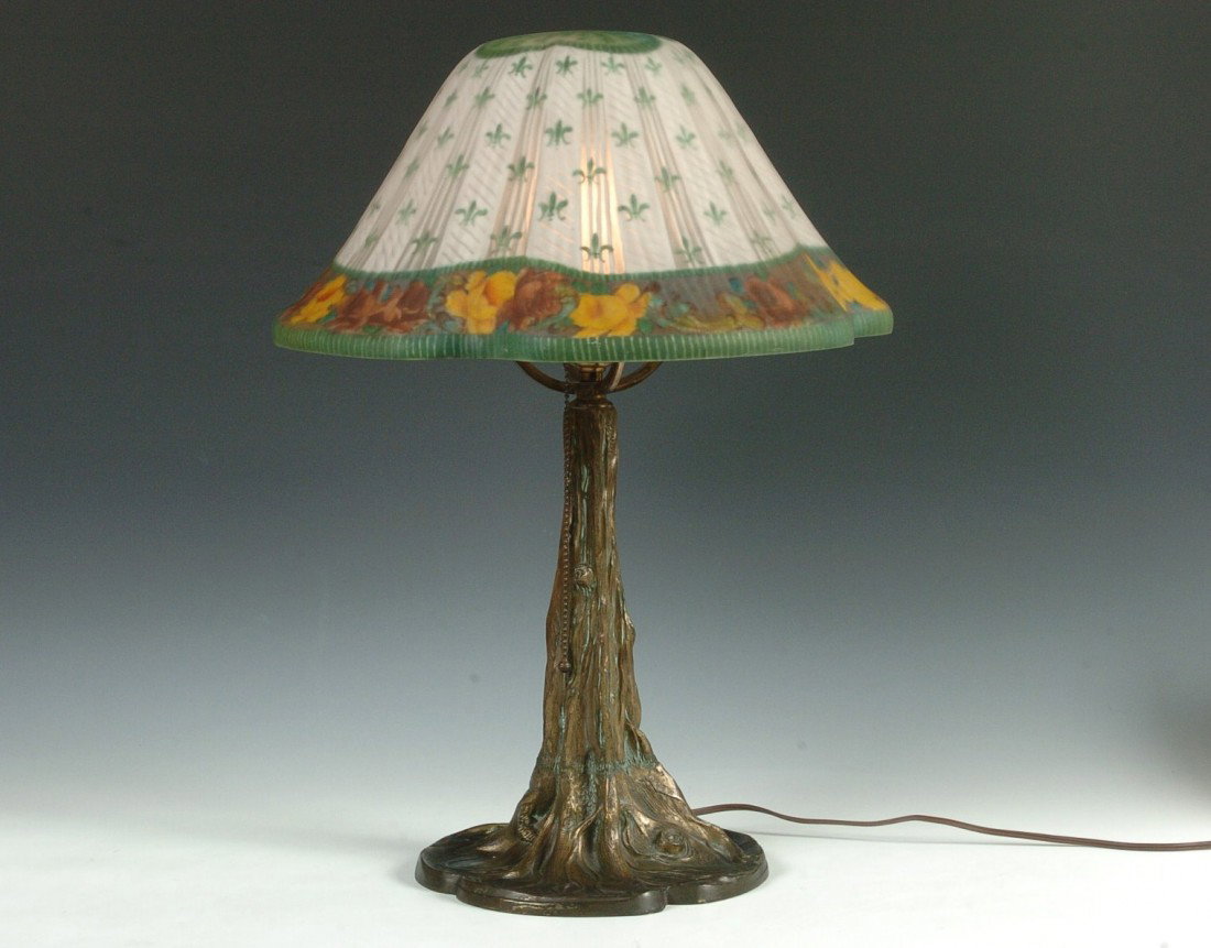A PAIRPOINT TREE TRUNK LAMP W/ ENAMELED SHADE: A tree trunk motif base signed Pairpoint, and an enameled Tivoli shade, no signature found on the shade. Measures 23 inches high with shade. The shade itself measures 15.75 diameter and 9 inches high.