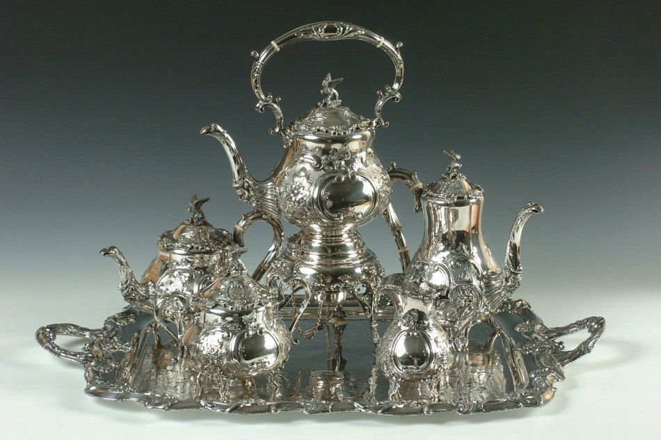 A VERY ORNATE MAPPIN & WEBB FOUR PIECE SILVER SERVICE: Five matching hand engraved footed serving pieces with bird finial, all signed Mappin & Webb Prince's Plate, London & Sheffield. Plus a similar silver plated tray unmarked. Included are a footed coffe