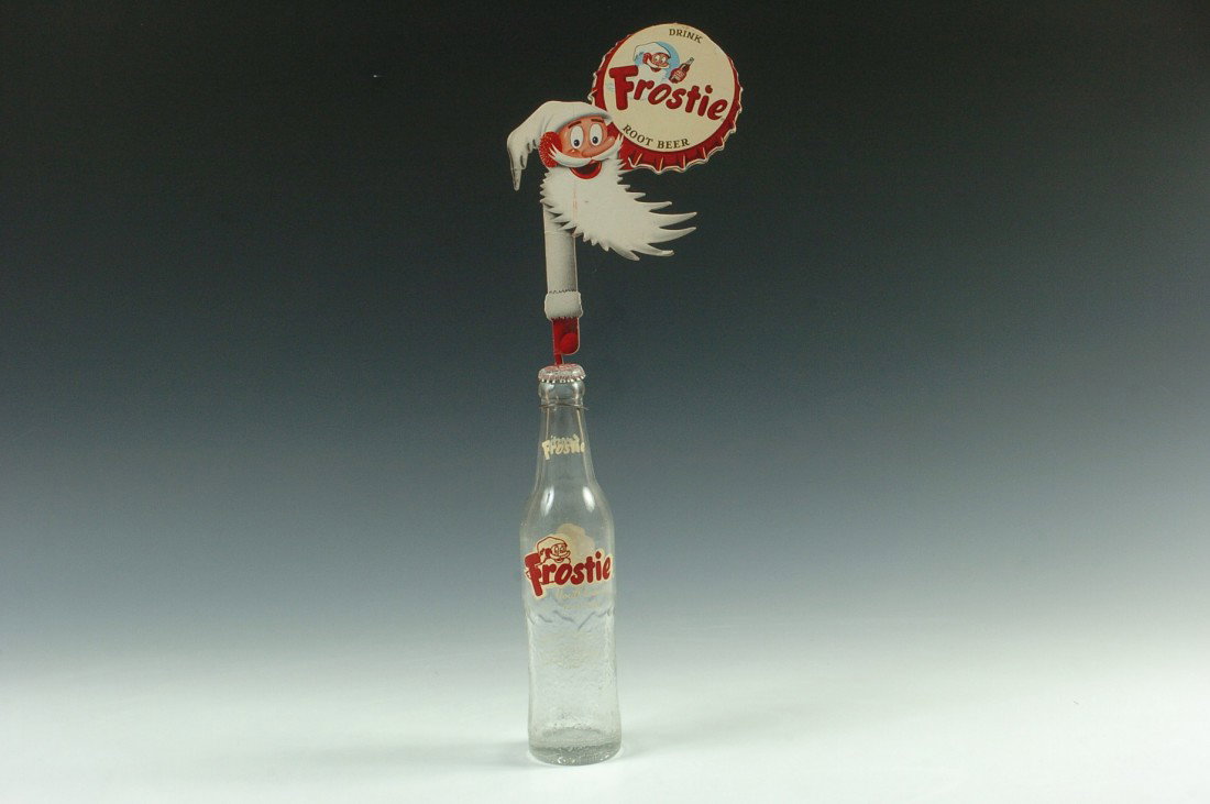 FROSTIE ROOT BEER BOTTLE AND CARDSTOCK DISPLAY: A capped clear glass bottle with textured lower half, full color cardstock and wire display attachment. Bottle measures 9.75 inches high, 18.5 inches with display.