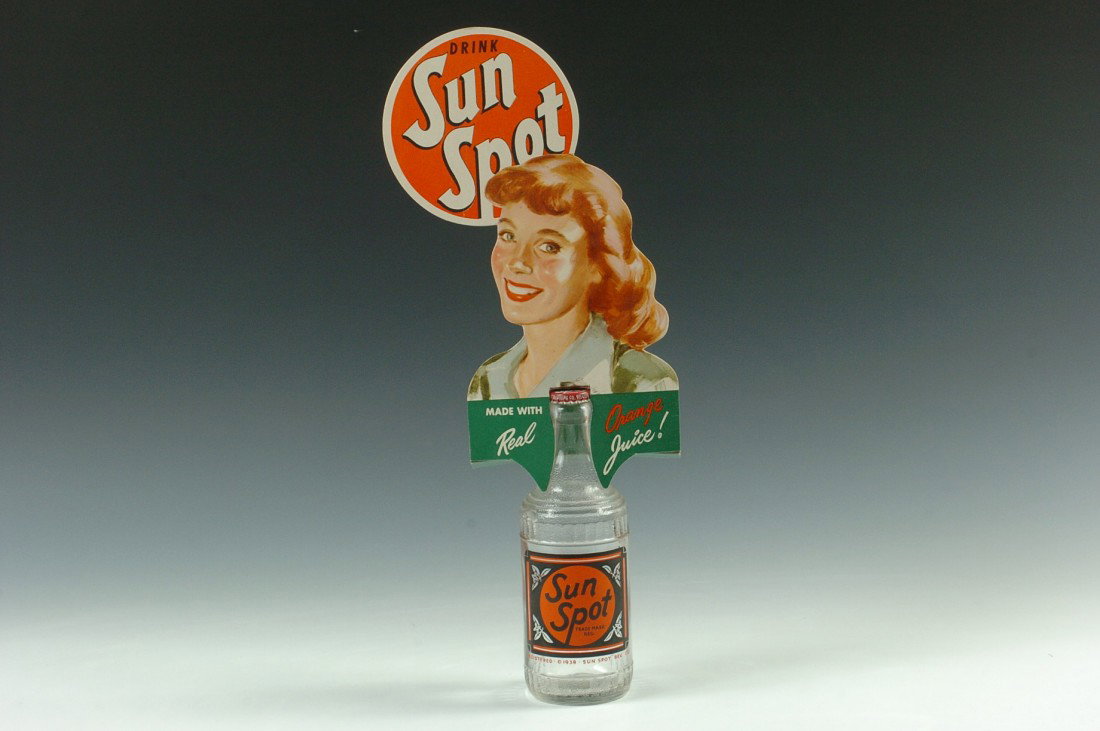 SUN SPOT BOTTLE AND CARDSTOCK DISPLAY: A capped clear glass bottle with 1938 registration date, full color cardstock display slip-over. Bottle measures 8 inches high, 17.25 inches with display.