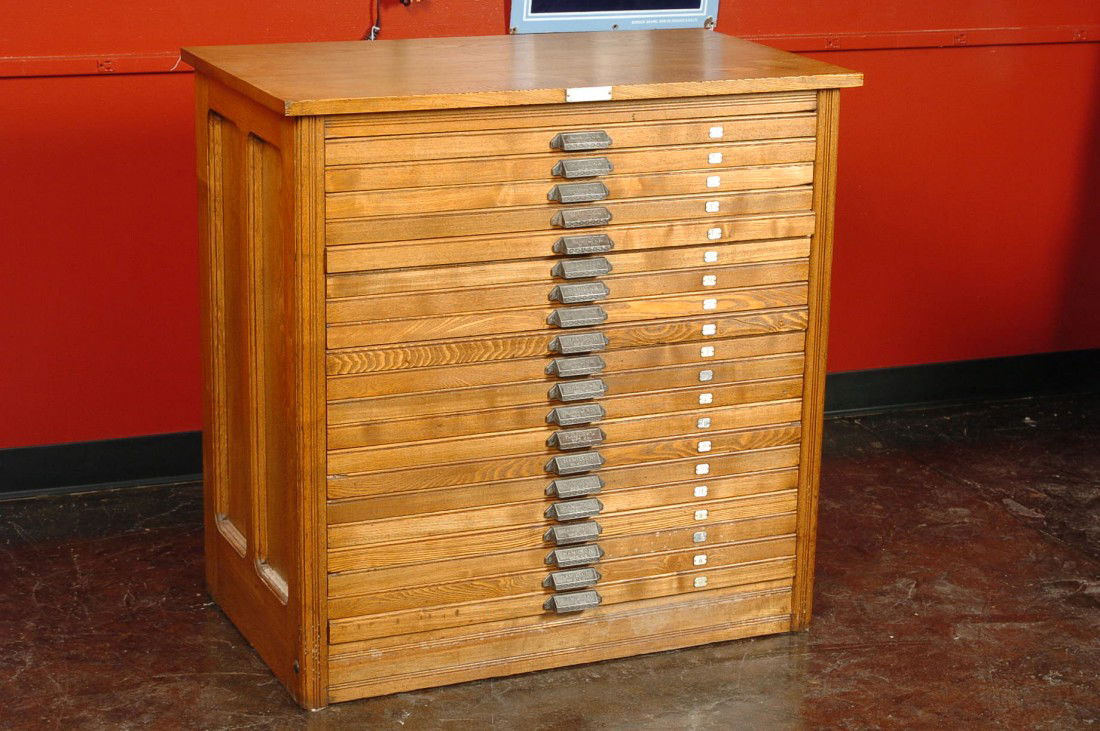 A TWENTY DRAWER PRINTER'S CABINET, C. 1890: Hamilton company tag affixed to top front. Each cast iron drawer pull with embossed 'Hamilton Mfg. Co.' Paneled sides. Measures 37 h x 37.5 l x 21.5 w inches.