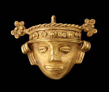 A PRE-COLUMBIAN STYLE 14K GOLD MASKETTE PENDANT: The depiction of a traditional mask is cast in approximately 14 karat gold with bail for wearing as a pendant. Tests to at least 14 karat. Originally, the gold figurines and depictions created by the