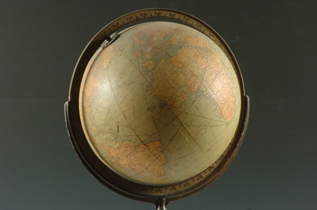 A 12-INCH TERRESTRIAL LIBRARY GLOBE ON STAND: A terrestrial globe on a walnut stand, measures 36 x 12 inches overall. Made by Replogle Globes Inc.