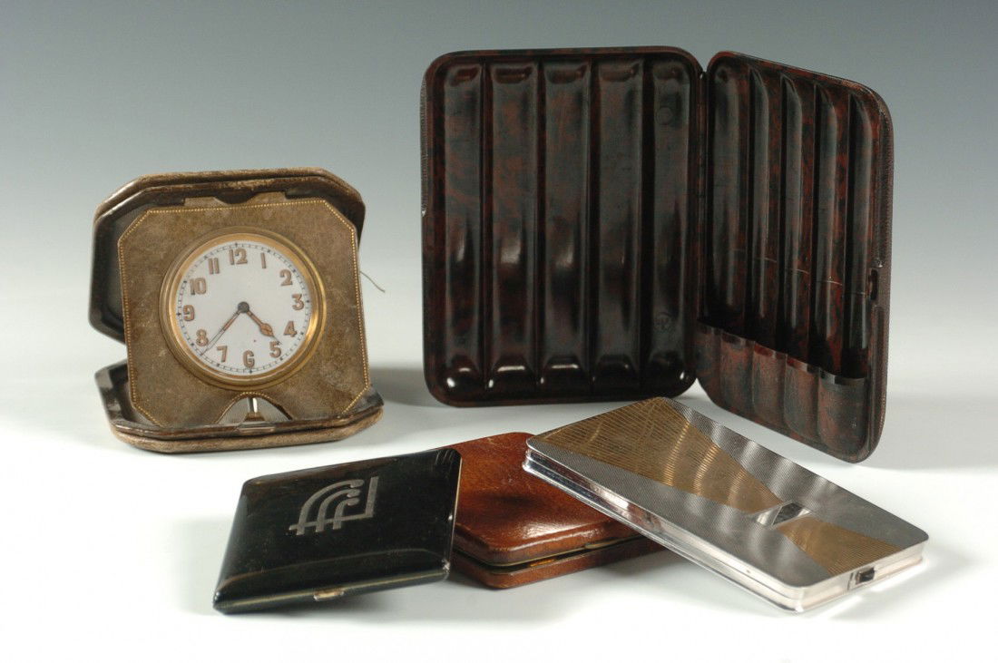 FIVE ART DECO ARTICLES: Includes a German-made 'DRP' marked bakelite cigar holder, three smaller cigarette holders, and a leatherette covered desk clock, enamel face marked 'Swiss.' Largest piece measures 6 x 4.5 inches; sma