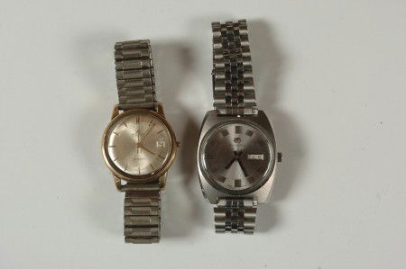 TWO BUCHERER MEN'S WRIST WATCHES: A stainless model with day and date, serial number 30148. Plus a gold-filled model, 25 jewels, automatic, date readout, heavy wear.