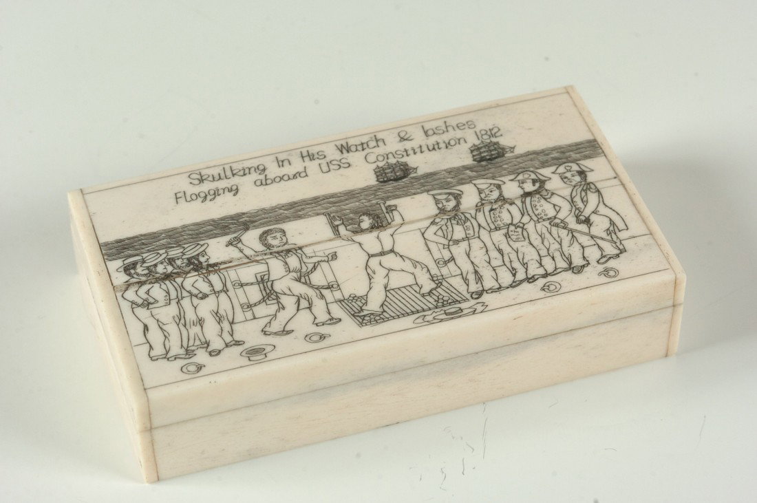 FLOGGING ABOARD USS CONSTITUTION SCRIMMED IVORY BOX: A hinged lid box of unknown age with scrimmed image on the cover and title 'Skulking In His Watch & lashes Flogging aboard USS Constitution 1812", measures 1 x 2.25 x 4.5 inches. NO INTERNATIONAL SHIP