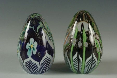TWO INTERNALLY DECORATED ORIENT AND FLUME PAPERWEIGHTS: Two egg form paperweights with internal decoration: Butterfly among rising tendrils signed Orient & Flume COE9n 1979 4 x 3 inches, floating blossoms against cobalt ground signed Orient & Flume CE 348