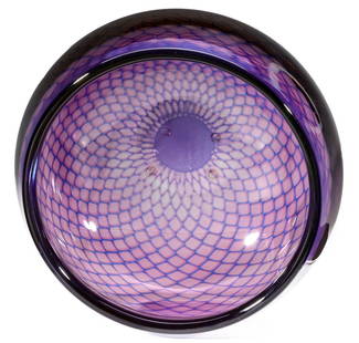 A SVEN PALMQVIST KRAKA BOWL FOR ORREFORS: The graceful, slightly swollen form displays an internal latticework decoration of jewel-tone blue within intensely colored amethyst glass shading to reddish plum. The base is engraved ORREFORS Kraka