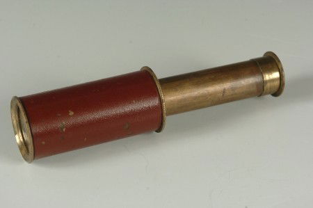 SMALL HAND TELESCOPE: Brass barrel, burgundy painted main barrel. Low magnification, clear optics. Measures 4.5 inches when open.