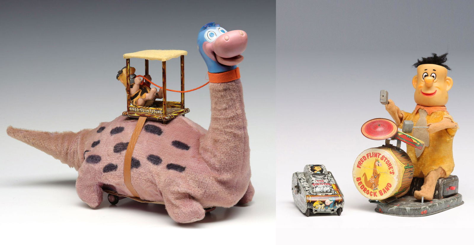 FRED FLINTSTONE BATTERY OP AND WIND-UP TOYS: 1. Fred Flintstone on Dino battery operated toy by Louis Marx. 2. Fred Flintstone's Bedrock Band battery operated toy, lithographed tin with vinyl head. 3. Flintstones lithographed tin wind-up roll-ov