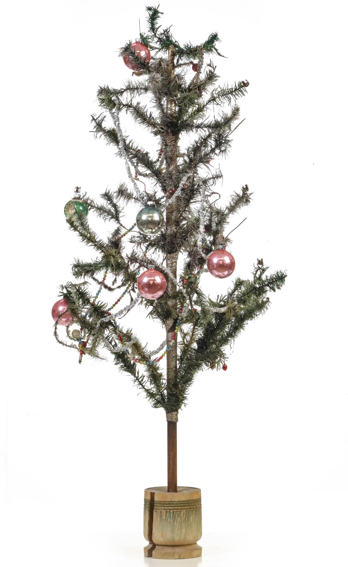 A VICTORIAN FEATHER TREE WITH TURNED WOOD BASE: A 44-inch overall example with some remaining silver foil trunk wrap, turned wood base with original paint and a few antique ornaments. Without proof of exemption,, be aware that internet sales tax ap