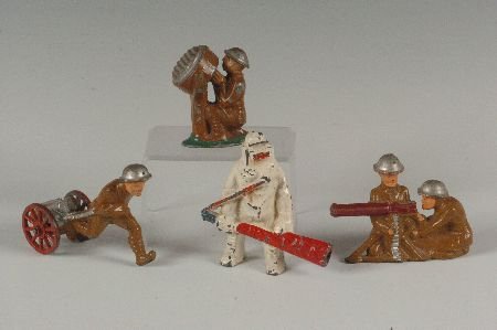 FOUR MANOIL SLUSH CAST WWI TOY SOLDIERS: All unusual examples including two figures and machine gun, one pulling artillery, one operating a search light, one with flame thrower embossed 'Hot Pappa' approximate sizes 2.50 x 3.25 inches, 2.50 