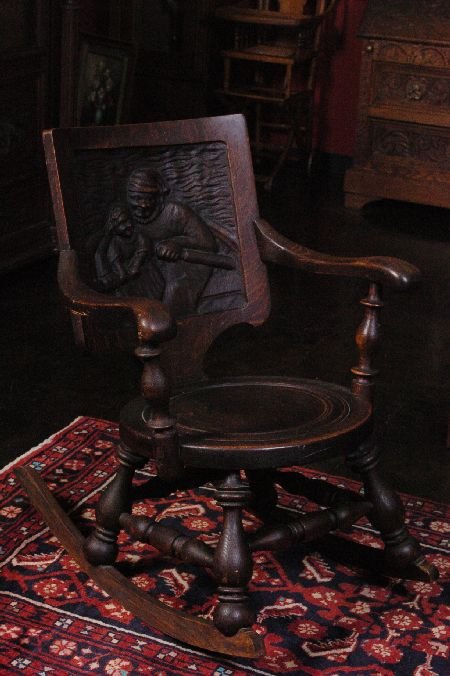 OAK ROCKING TAVERN CHAIR WITH DEEP CARVED BACK: Original dark finish, measures 32 x 33 x 24 inches.