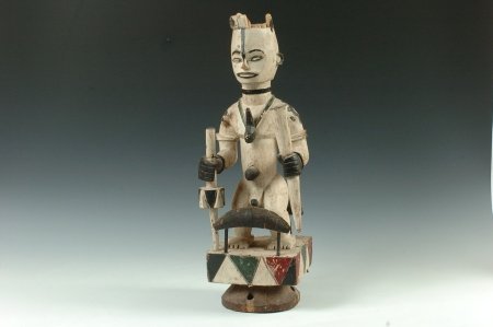 IBO COURTROOM FIGURE, NIGERIA: Carved wood figure of a man painted white, black, red and green holding an elephant trunk in one hand and a wand in another. It is used to swear upon. 21 x 8 inches.