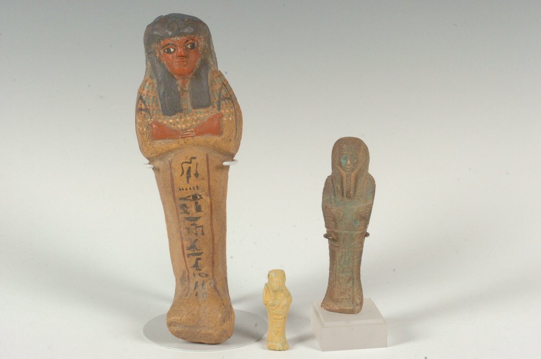 THREE EGYPTIAN USHABTI FIGURES: Clay with painted features and hieroglyphics, 7 inches; one of faience, four inches; and one of bright yellow faience with a bead hole, 1.75 inches. Not guaranteed to be ancient, but assumed to be rep
