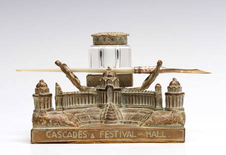 A 1904 ST. LOUIS WORLD'S FAIR SOUVENIR INK STAND: The figural ink stand with impressed lettering around the base 'Cascades & Festival - Hall, St. Louis, 900 Feet Wide 1100 Feet Deep, 1904,' includes a glass inkwell with lid and mother of pearl pen. 