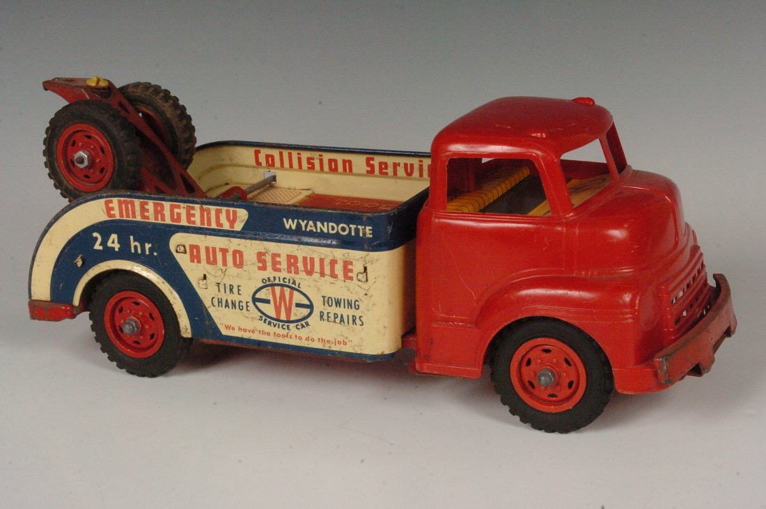 WYANDOTTE AUTO SERVICE TOW TRUCK CIRCA 1950'S: Auto Service Tow Truck, Wyandotte toys 1950s, plastic truck cab tin litho back. Measures 5.75 x 14.5 inches.