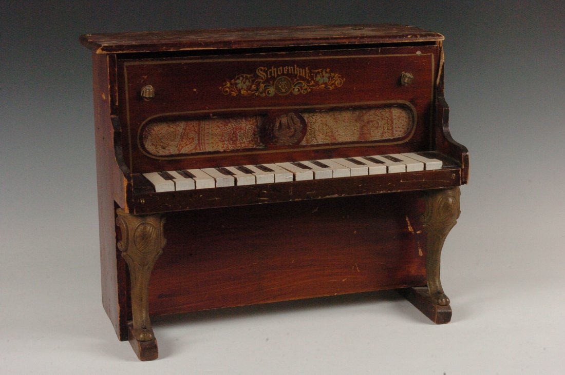 C. 1900 SCHOENHUT PIANO WITH CAST IRON LEGS: Schoenhut upright piano with painted wood, Schoenhut logo decal, cast iron front legs, 14 x 16.5 inches.
