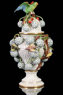 A LARGE MEISSEN PORCELAIN SCHNEEBALLEN URN WITH COVER: The bolted urn of baluster form on stand with cover is encrusted in hundreds of applied porcelain blossoms, birds, vines, woody stems and 'schneeballen' or snowballs. The base bears the crossed swords