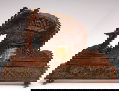 A 1930s FOLK ART CARVING ATTRIBUTED TO A KANSAS INMATE: The solid walnut carving of a G.O.P. elephant on long trapezoidal platform is centered by a picture frame and lettered along the base in bas relief. A pop-up elephant figure backs the picture frame. P