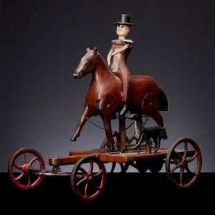 A VERY FINE EX-KAHN COLLECTION FOLK ART PULL TOY C 1880: The figures of a man in top hat on horseback with his dog move in fully animated strides above a walnut platform on axles with iron-spoked wheels. A cloth tag with accession numbers and the name Kahn