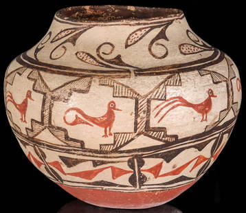 A 19TH CENTURY ZUNI PUEBLO POTTERY OLLA WITH RED BASE: The nice, large olla with convex collar above the swollen shoulder is decorated by a band of repeating stylized bird figures in geometric reserves above traditional designs and an unusual base finish