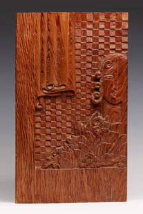 AN ART DECO INFLUENCE FOLK ART CARVED PANEL: The found object in the medium of yellow pine is relief carved with linen fold, checkerboard squares and the motif of stylized florals often seen in terra cotta relief on 1930s architecture. The half-