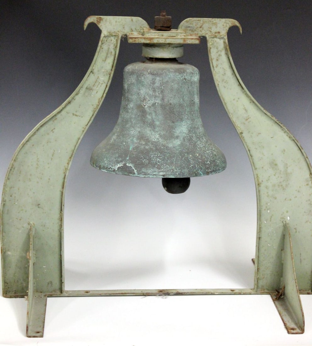 A 12-INCH DIESEL LOCOMOTIVE BELL: The brass or bronze bell mounted in an iron stand is stamped 7 1 2 S 7 1 around the top and embossed SALEM 506 on the clapper which is also lettered DOUBLE ACTING. Measures 25 x 27 x 18 inches. The be