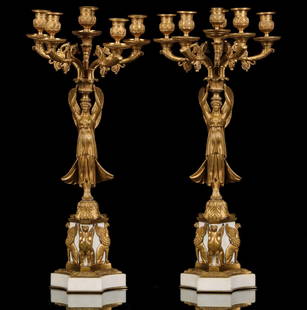 A PAIR LATE 19C. FRENCH EMPIRE FIGURAL CANDELABRA: The fine ormolu bronze and marble pair feature the goddess Nike, Winged Victory, holding aloft six-arm candelabra while standing on a convex-sided Carrera marble plinth with griffin mounts and bronze