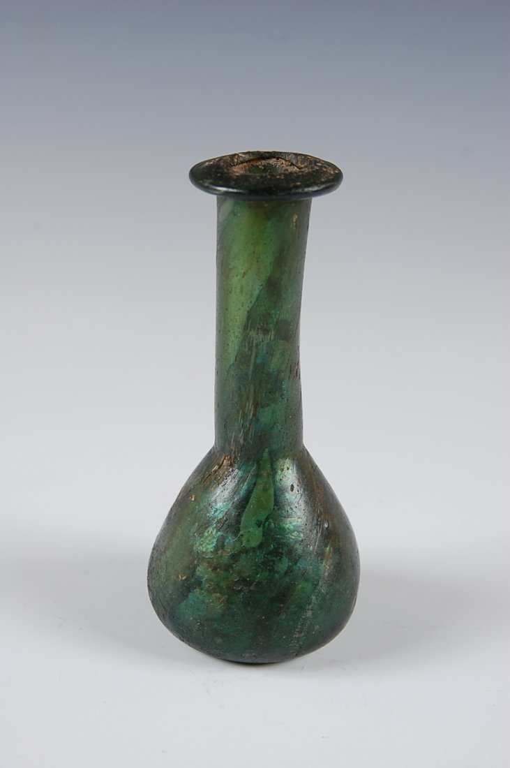 ANCIENT ROMAN GLASS BOTTLE VASE CIRCA 100 TO 200 A.D.: Pulled dark green glass with iridescence, measures 5 inches.
