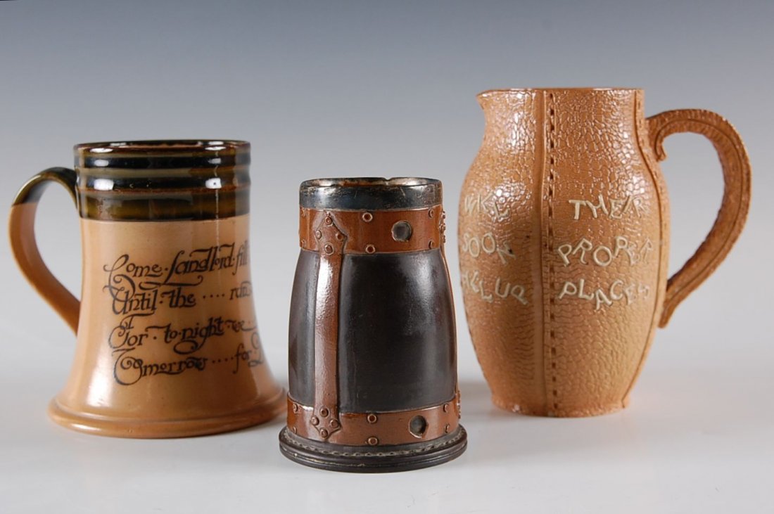 A DOULTON LAMBETH STONEWARE MOTTO JUG: Includes a Doulton cup with copper glaze and sterling silver rim, Chester marked, 4.25 x 3 inches. Motto jug measures 5.75 x 5 inches, and a 'Pots' mug by Doulton with motto to side, measures 5 x 4.5 