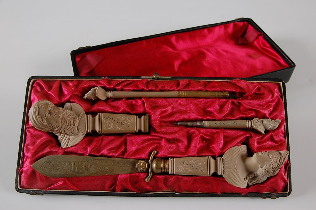 19TH C. GRAND TOUR CARVED LAVA DESK SET: A four piece carved pumice desk set with seal, dip pen, pencil, and letter opener with brass blade that reads 'Pompei'. Displayed in the original presentation box. Pompeii letter opener measures 9.5 i