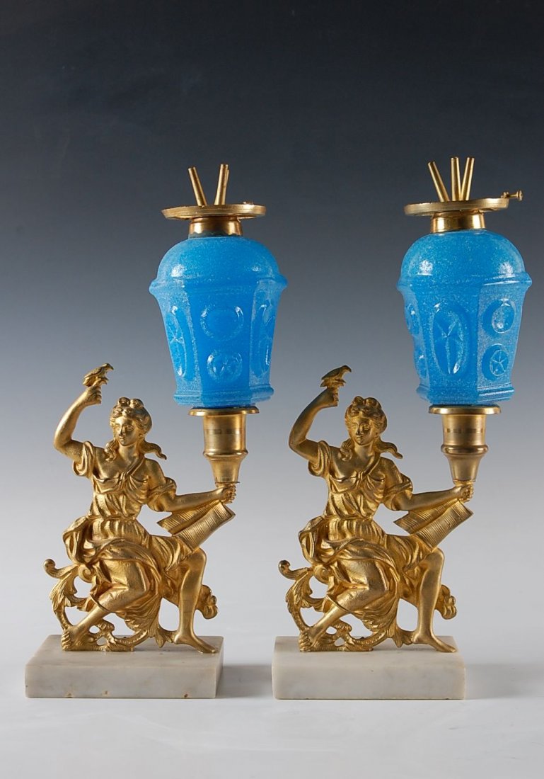 19TH C. GILDED BRONZE WHALE OIL GIRANDOLE LAMPS ON MARB: Pair of neo-classical gilded bronze figures on marble bases and supporting six-sided dome top blasted blue opaline glass whale oil lamp fonts. Fine quality casting and gilding, 14.5 inches high, the f