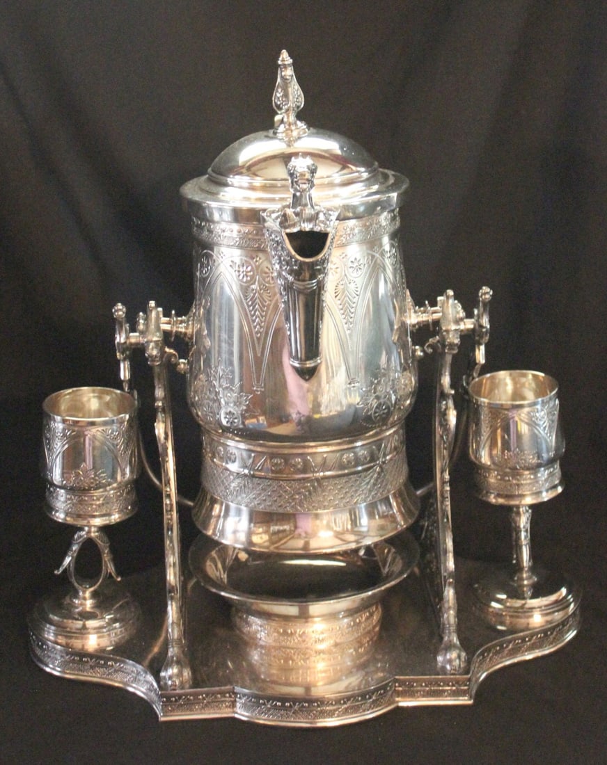 A MAJESTIC VICTORIAN WATER TIPPLER WITH GOBLETS: The ornate tippler with engraved decoration and horse head figural elements is an unusually nice example on its shaped platform base, two original goblets and exceptional condition. Measures 17.5 x 16