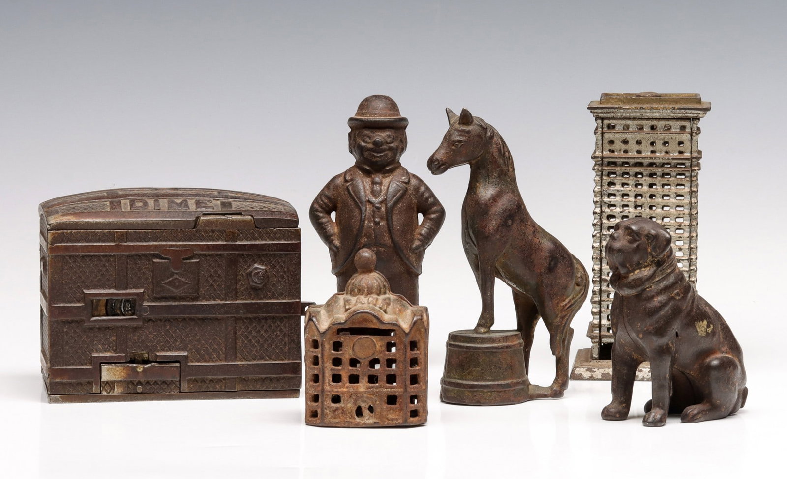 SIX ANTIQUE STILL AND SEMI-MECHANICAL CAST IRON BANKS: The collection of original antique cast iron banks in original finish is offered as shown, no reproductions. Measures from 3.25 to 5.25 inches. Without proof of exemption, be aware that internet sales