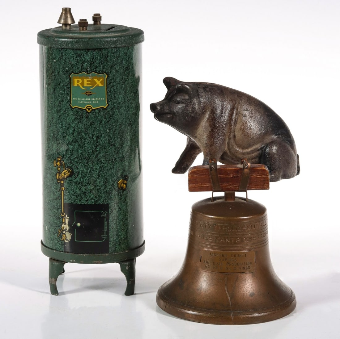 THREE ANTIQUE BANKS INCL REX WATER HEATER ADVERTISING: 1. Antique cast iron figural pig still bank. Measures 3 x 4.75 inches. 2. REX Water heaters lithographed tin advertising bank. Measures 8 x 3 inches. 3. Jackson County Savings Liberty Bell Bank Patent