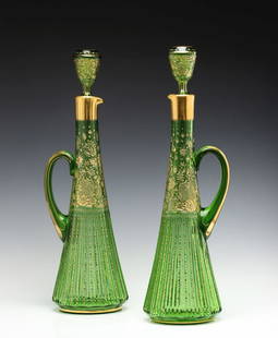 MOSER FINE ENGRAVED AND ZIPPER CUT 22-INCH EWER PAIR: The high-quality pair with applied handle and nicely fitted stopper are each decorated with a solid gold band encircling the rim above finely engraved and gilded motifs of rocaille and rococo swirls