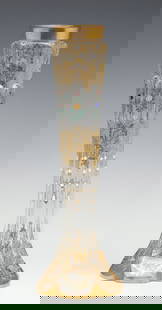 A MOSER VASE WITH CABOCHONS AND MULTI-TECHNIQUE ENAMELS: The tall, slender, crystal vase with six flat sides has a circular gilded collar over platinum and gold enamel motifs of rocaille and rococo C-scrolls in relief surrounding the six oval cabochons in