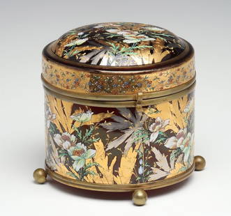 A MOSER DEEP RUBY BOX WITH GILT AND ENAMEL DECORATION: The deep ruby glass is decorated in an unusual manner with gold, platinum, and polychrome enamels. Measures 6.75 x 7.5 inches. Without proof of exemption, be aware that internet sales tax applies