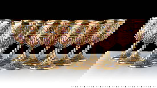 TWELVE OUTSTANDING MOSER GILT AND ENAMELED GOBLETS: Late 19th century. Each of the twelve lavish examples is comprised of a cranberry glass bowl on colorless stem decorated all-over in matte and gloss finish gold embellished with a band of swirling