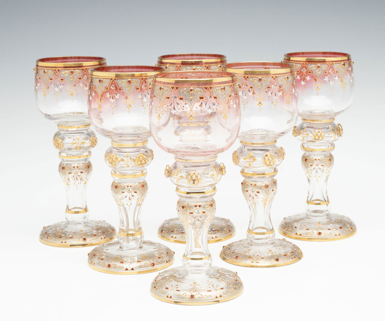 SIX JEWELED AND ENAMELED BOHEMIAN ART GLASS GOBLETS: Late 19th Century Each wine goblet is decorated in gold, enamels, glass beads as ruby jewels and glass prunt applications. Each measures 6.25 x 2.75 inches. Without proof of exemption, be aware that i